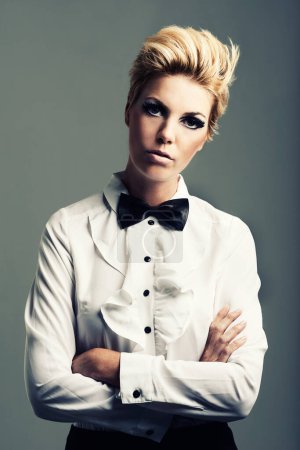 Photo for Portrait, bow tie and woman with fashion, vintage clothes and classy aesthetic on grey background. Arms crossed, edgy fashionable model or cool girl with retro style and makeup isolated in studio. - Royalty Free Image