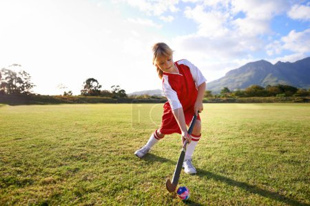 Photo for Girl, green grass and playing hockey for sports, game or outdoor match in nature for practice. Female person, kid or playful child enjoying competition with ball on field for fitness or training. - Royalty Free Image