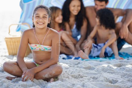 Téléchargez les photos : Fille avec la famille sur la plage, heureux dans le portrait et les vacances d'été avec des liens et de l'amour. Personnes en plein air, vacances au Brésil avec sable et soleil, sourire d'enfant femelle pour Voyage et aventure dans la nature. - en image libre de droit