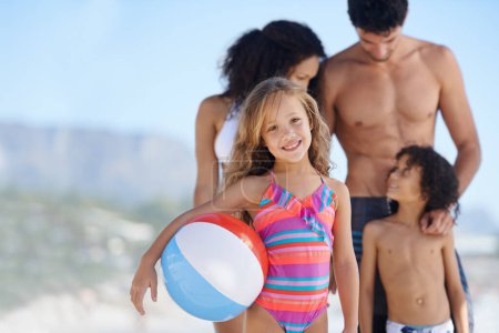 Photo for Happy child, portrait and beach ball with family for fun summer, weekend or outdoor holiday together. Little girl smile with mother, father and sibling for vacation on ocean coast or sea in nature. - Royalty Free Image