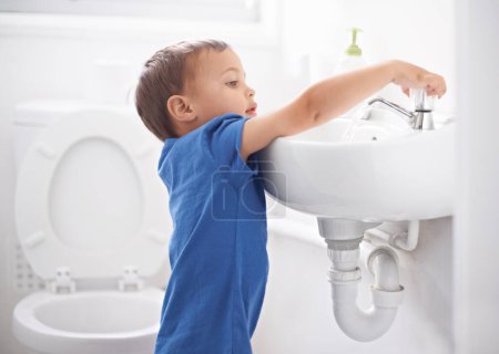 Foto de Niño, niño y lavarse las manos en el baño, higiene y prevención de gérmenes o bacterias en el hogar. Hombre, niño y aprendizaje en lavabo o limpieza y cuidado sanitario, agua y desinfección por seguridad. - Imagen libre de derechos