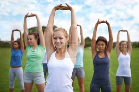 Téléchargez les photos : Femmes étirant les bras, en groupe et en plein air pour l'exercice sur le terrain de sport et cours de fitness. Santé, bien-être et entraînement ensemble, entraînement en équipe de jeunes athlètes dans le parc et activité physique avec échauffement. - en image libre de droit