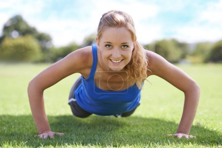Photo for Women, face and push ups on grass for exercise with fitness, training and workout on sports field. Athlete, person and confidence on ground with physical activity for healthy body or wellness outdoor. - Royalty Free Image