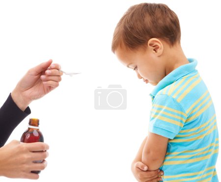 Photo for Hands, medicine and spoon for child in studio, sad and thinking with arms crossed by white background. Kid, mother and bottle for healthcare, pharmaceutical product and helping sick boy in profile. - Royalty Free Image