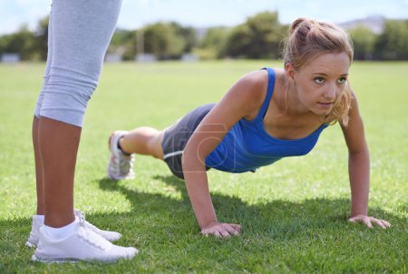 Photo for Women, face and push ups on grass for exercise with fitness, training and workout on sports field. Athlete, person and confidence on ground and coach or physical activity for healthy body or wellness. - Royalty Free Image