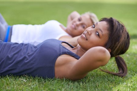 Photo for Happy woman, portrait and sit ups for outdoor exercise or workout in fitness together on green grass. Young active female person or people smile for training, health and wellness on field in nature. - Royalty Free Image