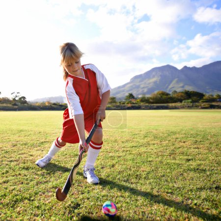 Photo for Girl, green grass and playing hockey for game, outdoor match or sports in nature for practice. Female person, kid or playful child enjoying competition with ball on field for fitness or training. - Royalty Free Image