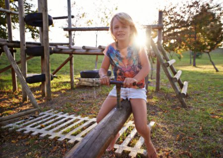 Photo for Happy girl, portrait and riding seesaw in park sunset for fun holiday, weekend or outdoor break in nature. Face of female person, kid or child smile on playground for childhood activity outside. - Royalty Free Image