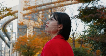 Foto de Pensando, mujer al aire libre y japonesa en la ciudad para viajar en tren en otoño con árboles y felicidad. Parque, la naturaleza y la persona de negocios en Tokio para desplazarse por la mañana en metro transporte. - Imagen libre de derechos