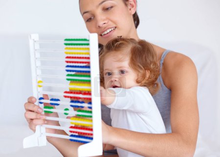 Photo for Abacus, playing and girl baby with mother for math, learning and teaching for child development on bed. Bonding, toy and young mom with kid, infant or toddler with counting in bedroom at home - Royalty Free Image