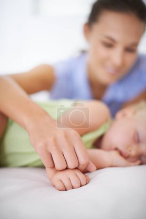 Photo for Hands, sleeping and mother with baby on bed for bonding, relax and sweet cute relationship. Happy, smile and young mom watching girl child, kid or toddler taking a nap in bedroom or nursery at home - Royalty Free Image