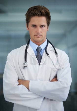Photo for Serious, crossed arms and portrait of man doctor with stethoscope for confident attitude. Career, pride and professional young male healthcare worker in medical office of hospital or clinic - Royalty Free Image