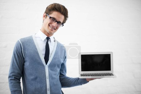 Foto de Hombre feliz, retrato y pantalla portátil para publicidad o marketing en un fondo de estudio gris. Persona masculina, sonrisa nerd o geek con computadora, pantalla tecnológica o espacio de maqueta para publicidad, IU o UX. - Imagen libre de derechos