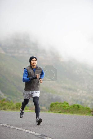 Photo for Fitness, health and a man in the street for running, training and marathon competition. Winter, energy and a male runner or athlete in the road for sports, morning cardio or a workout in nature. - Royalty Free Image