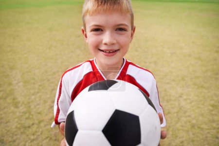 Photo for Boy, soccer player and ball with portrait, smile and ready for game, field and child. Outdoor, playful and sport for childhood, happy and athlete for match, alone and outside on football pitch. - Royalty Free Image