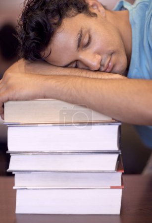 Foto de Estudiante, durmiendo y pila de libros para la educación, el desarrollo o agotado con la fatiga en la biblioteca de la universidad. Persona, aprendizaje y descanso con agotamiento, cansancio o salud mental para examen en la universidad. - Imagen libre de derechos