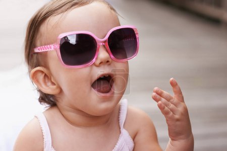 Photo for Baby, laugh and sunglasses outdoor with summer, youth fashion and young girl on holiday. Kid, fun frames and happy on vacation with shades style, child clothes and trendy accessory of toddler. - Royalty Free Image