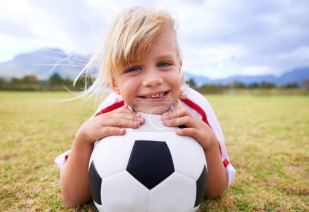 Photo for Child, soccer player and ball with portrait, smile and ready for game, field and girl. Outdoor, playful and sport for childhood, happy and athlete for match, alone and outside on football pitch. - Royalty Free Image