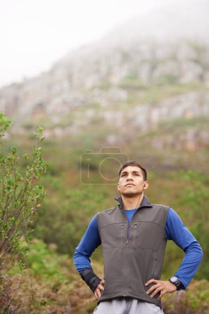 Photo for Man, hiking and earphones for music, mountain and thinking for adventure, exercise or workout. Hiker, fitness and young for training, forest and nature to explore, hobby and heart health in outdoors. - Royalty Free Image