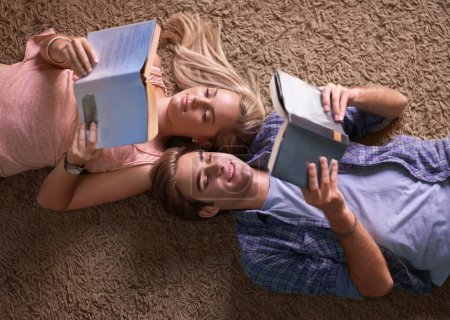 Photo for Couple, reading and lying on floor for studying, scholarship or happy for development at university. Above man, woman or education in textbook for knowledge, information or research at college campus. - Royalty Free Image