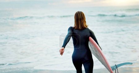 Photo for Surfing, beach and woman with surfboard running for water sports, fitness and freedom by ocean. Nature, travel and back of person on holiday, vacation and adventure by sea for hobby, fun and coast. - Royalty Free Image
