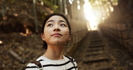 Photo for Nature, thinking and Japanese woman in forest for adventure on holiday, vacation and morning. Travel, relaxing and person with natural plants in woods for freedom, walking and explore in Kyoto. - Royalty Free Image