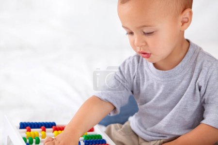 Foto de Abacus, matemáticas y aprendizaje del bebé del niño, jugando y enseñando para el desarrollo del niño en la cama. Preescolar, la juventud y el primer plano del niño, bebé o niño pequeño con conteo de juguetes en el dormitorio o guardería en casa - Imagen libre de derechos