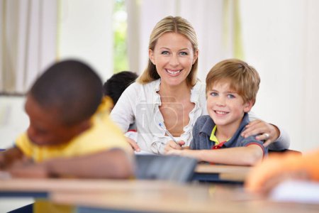 Photo for Portrait of happy teacher, child or writing in classroom for learning, education and helping for development. Woman teaching, hug or boy student with knowledge, support or notebook at middle school. - Royalty Free Image