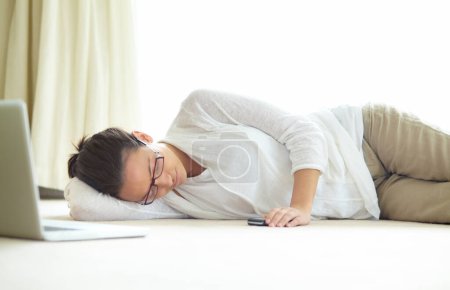 Téléchargez les photos : Travail à distance, burnout et femme fatiguée dormant sur un sol à faible énergie, épuisé ou sieste après projet d'ordinateur portable. Indépendant, fatigué ou femme dans le salon, rêvant ou faisant une pause à la maison. - en image libre de droit