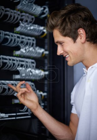 Photo for Server room, man and check cables with smile, thinking and connectivity with hardware in night. Cybersecurity system, it network and technician for glitch, data center and problem solving for error. - Royalty Free Image