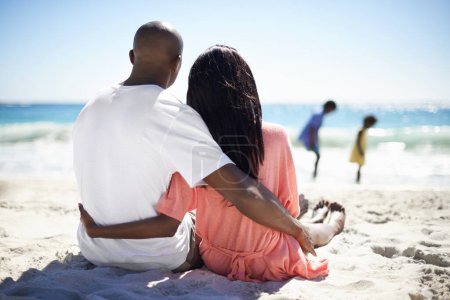 Photo for Black family, relaxing on beach and hug with back, sand and married for summer vacation. African, resting and happy for holiday, children and seaside in outdoor, beautiful and day off in ocean. - Royalty Free Image