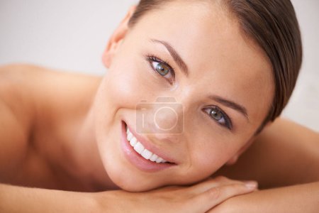 Téléchargez les photos : Détendez-vous, heureuse et jeune femme au spa avec massage du corps pour la santé, le bien-être et l'auto-soin. Sourire, personne naturelle et féminine avec un traitement de thérapie de la peau calme, paisible et sereine au salon de beauté - en image libre de droit
