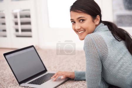 Foto de Retrato de la mujer en la alfombra con el ordenador portátil, sonrisa y relajarse con el estudio, la investigación y navegar por la web en la sala de estar. Chica estudiante feliz en el suelo con la computadora, elearning y la educación en línea en el hogar - Imagen libre de derechos
