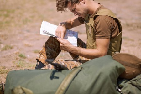 Photo for Man with map on battlefield, planning battle location or tactical operation goals for mission in war. Soldier is outdoor at military base camp, check strategy paperwork with army target and attack. - Royalty Free Image