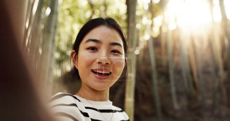 Photo for Japanese woman, selfie and bamboo forest for portrait with smile, pride and bush for post on web blog. Girl, person and happy influencer on adventure, trekking and hiking by trees for social network. - Royalty Free Image