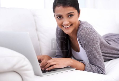 Photo for Portrait, home and woman with a laptop, smile and typing in a living room, internet and connection. Face, person on a couch or girl in a lounge, technology and website with daily blog and digital app. - Royalty Free Image