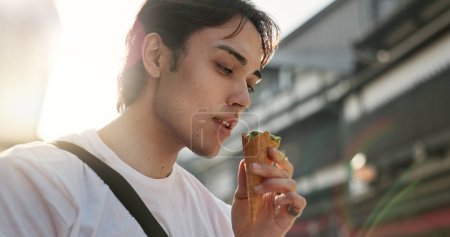 Photo for Ice cream, eating and Japanese man in city on vacation, holiday and adventure in Yokohama town. Travel, weekend trip and person with dessert, sweet snack and cone in street for tourism destination. - Royalty Free Image