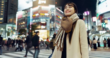 Photo for Night, walking and young woman in the town for exploring on vacation, adventure or holiday. Happy, travel and beautiful Asian female person by public transport for sightseeing on weekend trip in city. - Royalty Free Image