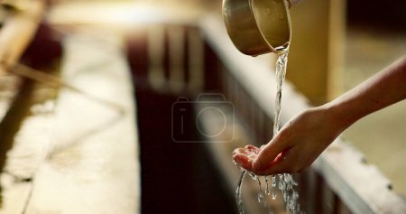 Téléchargez les photos : Temple shinto, gros plan et se laver les mains avec de l'eau dans un récipient pour le nettoyage, la foi et le bien-être. Religion, pleine conscience et rituel de purification pour arrêter le mal, les bactéries et la paix au sanctuaire de Tokyo. - en image libre de droit