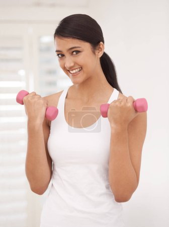 Foto de Mujer, retrato y pesas para hacer ejercicio en el gimnasio, fitness y fuerte crecimiento de bíceps o músculos. Mujer feliz, sonriente y con pesas para ejercitarse y entrenar, equipo y herramientas para deportista. - Imagen libre de derechos