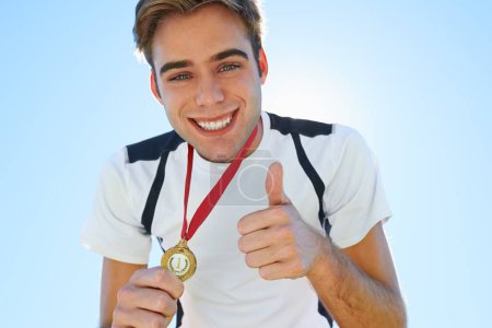 Photo for Athlete, portrait and thumbs up with medal for sports achievement, success and yes in competition. Face of winner, runner or man with like, prize or good job hands, emoji and gold award on a blue sky. - Royalty Free Image