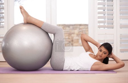 Photo for Exercise, pilates and ball, woman and sit ups for core training, health and workout with gym equipment at home. Body, wellness and fitness with crunches for abs, challenge and strong in apartment. - Royalty Free Image