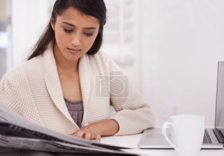 Photo for Woman, morning newspaper and reading in home by laptop for remote work, economy or check stock market. Person, trader and newsletter for financial stats, information or thinking by computer in house. - Royalty Free Image