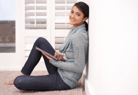 Foto de Retrato de mujer feliz en la alfombra en casa con la tableta, sonrisa y relajarse con el estudio, investigación y publicación en las redes sociales. Estudiante chica en el piso con aplicación digital, elearning y blog en línea en la sala de estar - Imagen libre de derechos