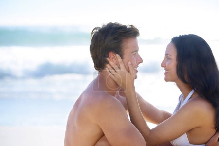 Téléchargez les photos : Embrassez, amour et couple heureux sur la plage pour des vacances romantiques aventure ensemble sur l'île tropicale avec plaisir. Souriez, hommes et femmes en vacances au bord de l'océan avec des vagues, des câlins et des maquettes en voyage à Bali - en image libre de droit