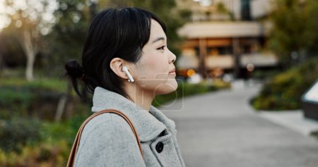 Téléchargez les photos : Femme japonaise, écouteurs et promenade dans la rue avec écoute, musique et abonnement streaming en ville. Personne d'affaires, technologie audio et son pour podcast, radio et Voyage sur le trottoir du métro à Tokyo. - en image libre de droit