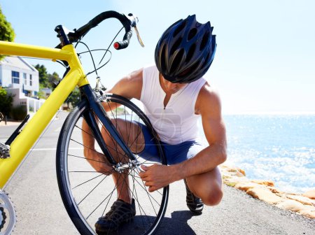Photo for Man, bicycle and tyre puncture or road change for safe transport, performance or repair. Male person, cyclist and ocean for gear improvement or endurance for triathlon training, sport or practice. - Royalty Free Image