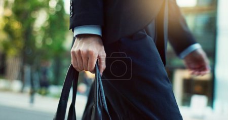 Photo for Legs, walking and person with bag, travel in city street and carbon footprint with buildings and commuter moving. Eco friendly commute to work, hands with urban CBD and motion with sustainability. - Royalty Free Image