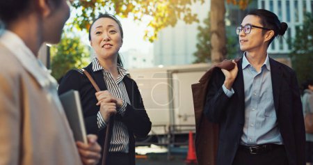 Photo for Meeting, conversation and business people in the city talking for communication or bonding. Smile, discussion and professional Asian colleagues speaking and laughing together commuting in town - Royalty Free Image