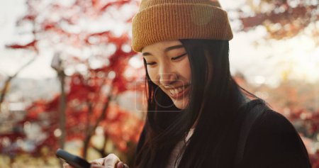 Téléchargez les photos : Selfie, voyage et femme japonaise en forêt pour des vacances, des vacances et des aventures au Japon. Heureux, sourire et personne prendre des photos sur smartphone dans la nature pour les médias sociaux post, souvenirs et blog en ligne. - en image libre de droit
